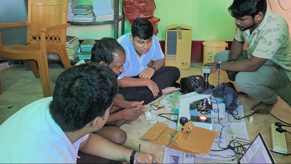The SeriScope team examining samples with a microscope and connected computer